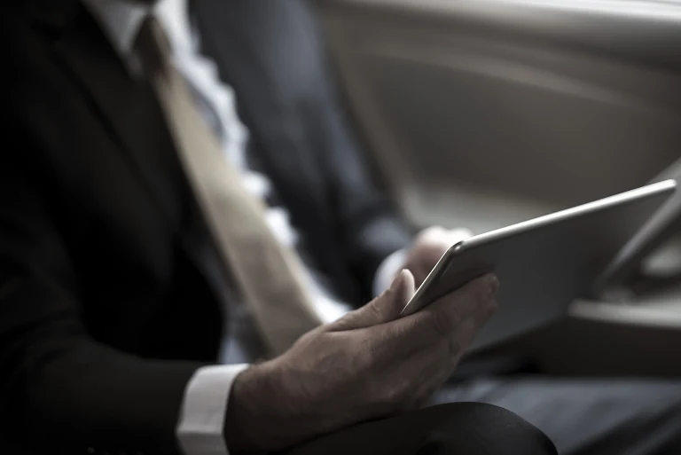 A businessman in a suit holding a tablet