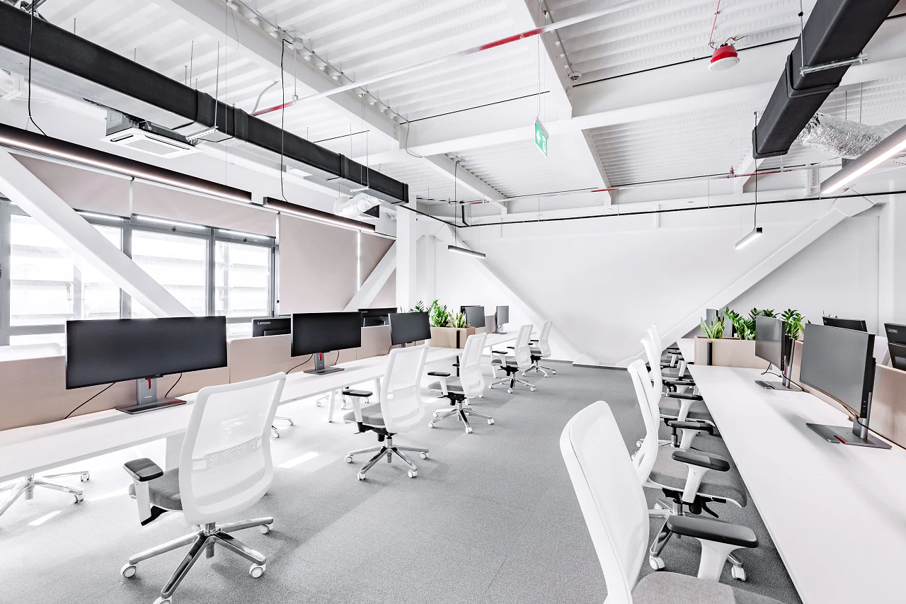 Long rows of white desks with twin monitors