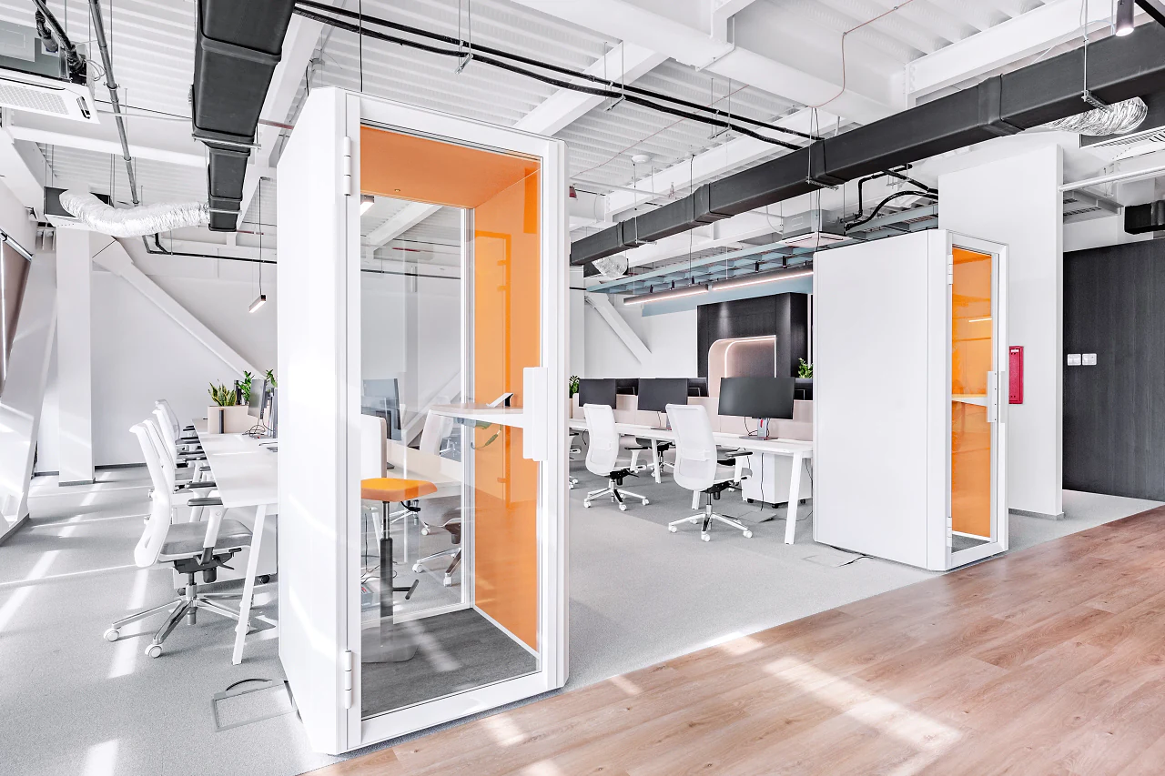Orange-lined phone booths beside the open desks