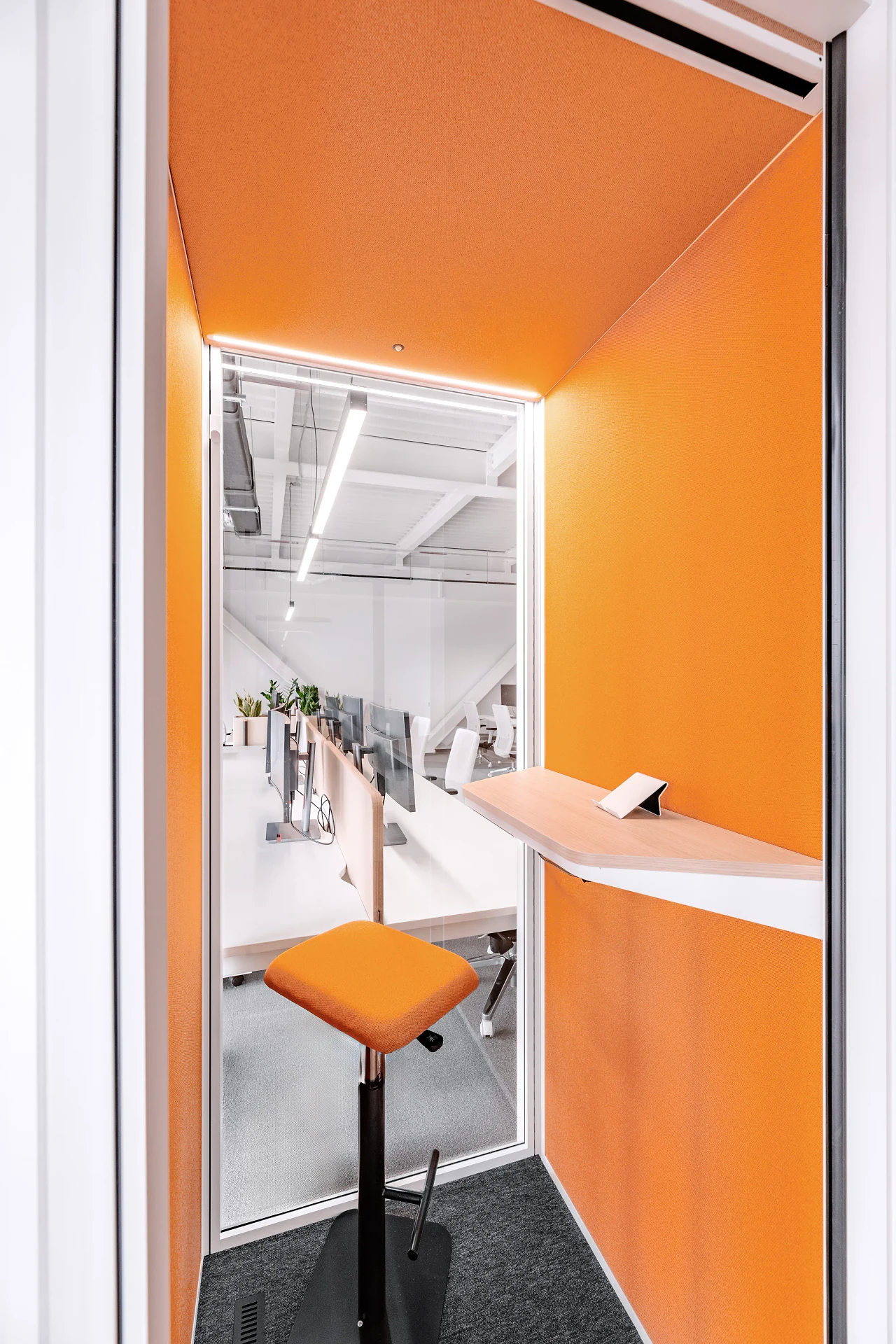 Inside an orange phone booth with a standing desk