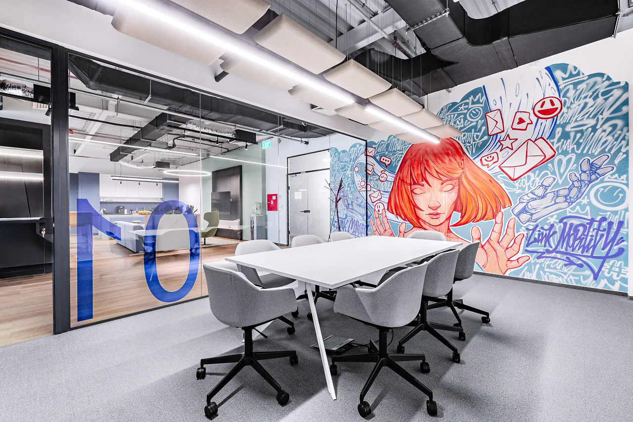 A meeting room with a large mural of a red-haired woman and a blue numeral on the glass