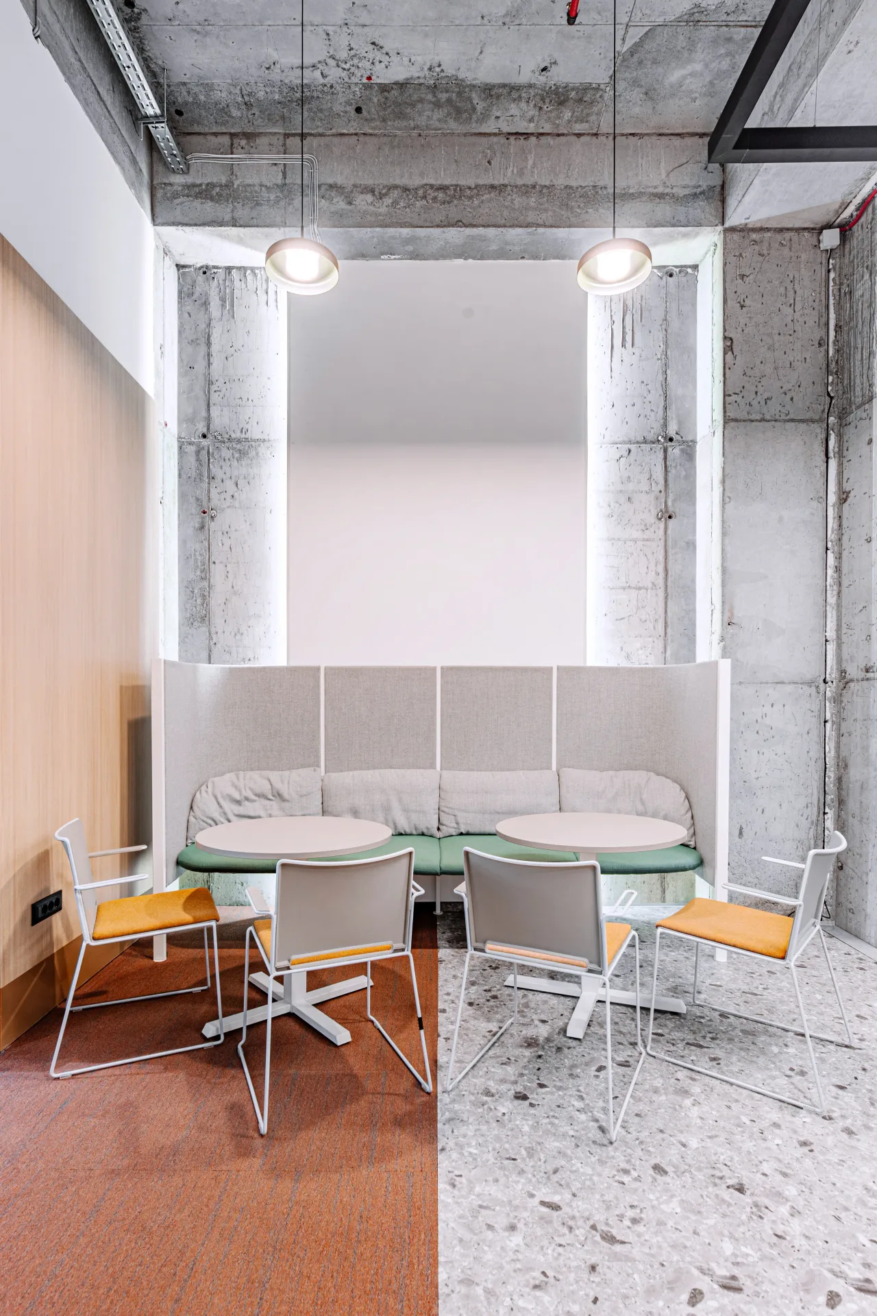 A meeting nook with a high-backed sofa and a round table