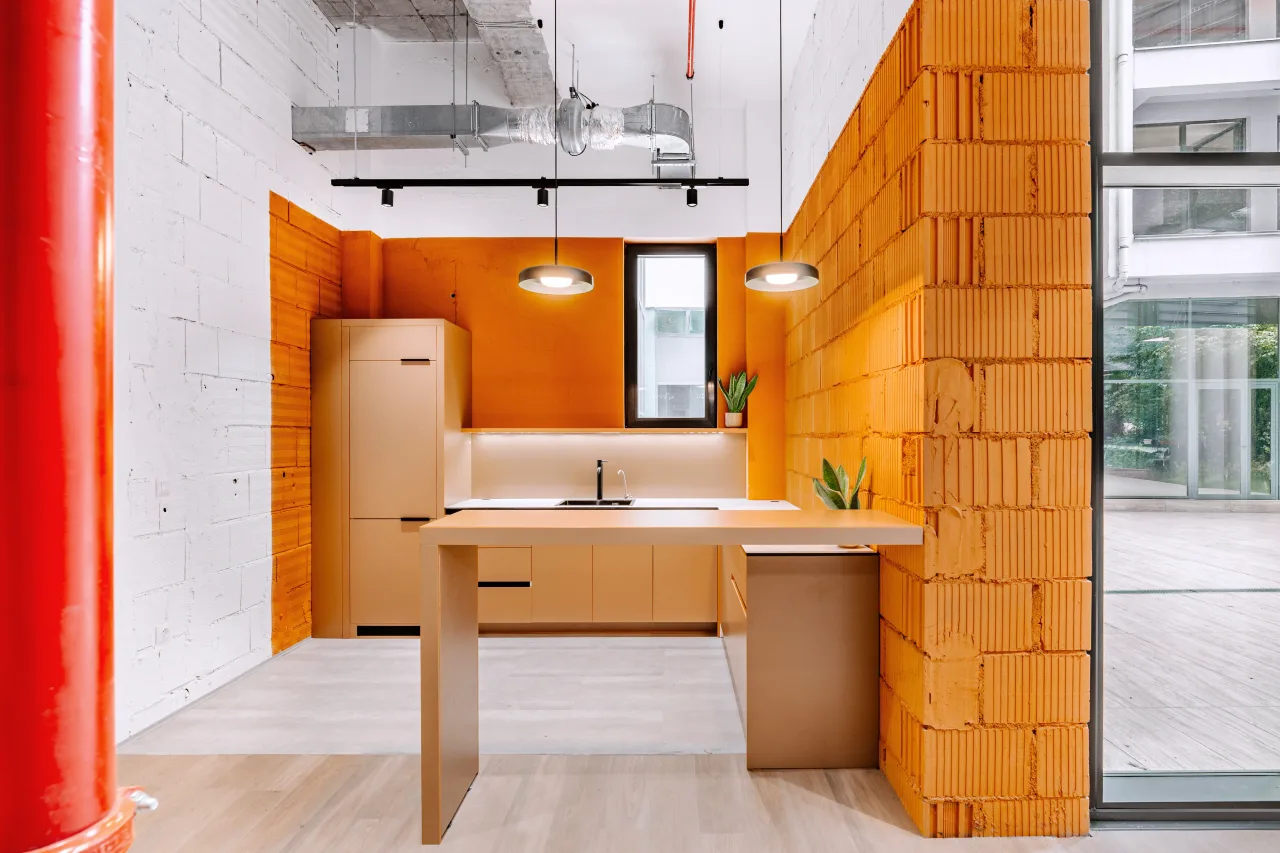An orange brick kitchen beside a red column