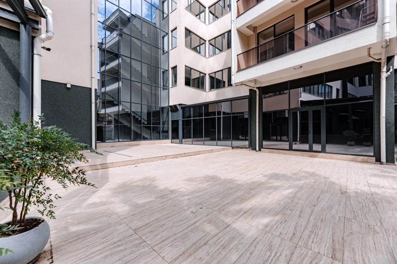 The building's courtyard with planting in front of the glazed ground floor