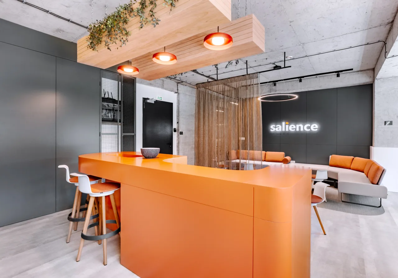 A kitchen with grey arched cabinetry, open shelving and an orange counter