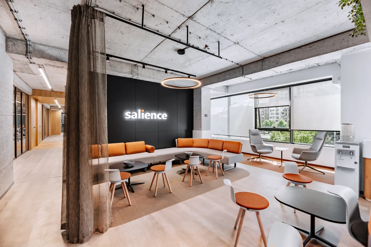 The orange kitchen bar under a hanging planter, the lounge beyond