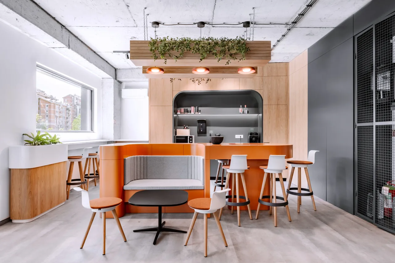 A kitchen bar with booth seating, white stools and a hanging planter