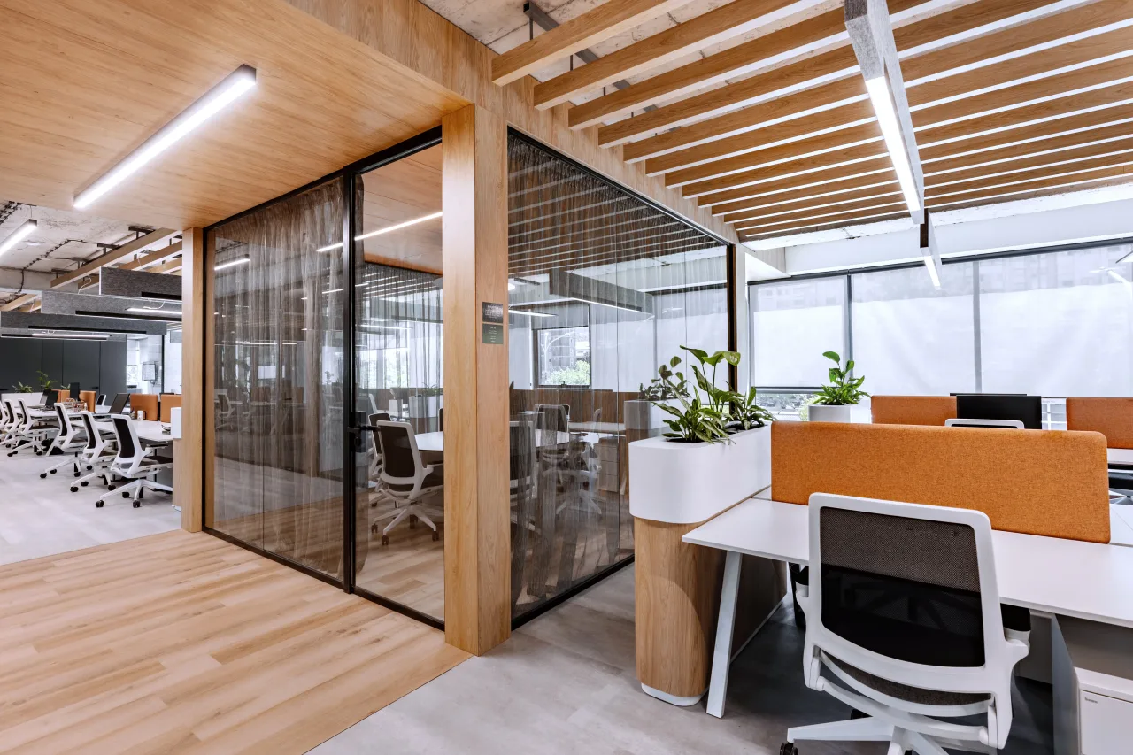 Desks with orange screens behind a glass partition