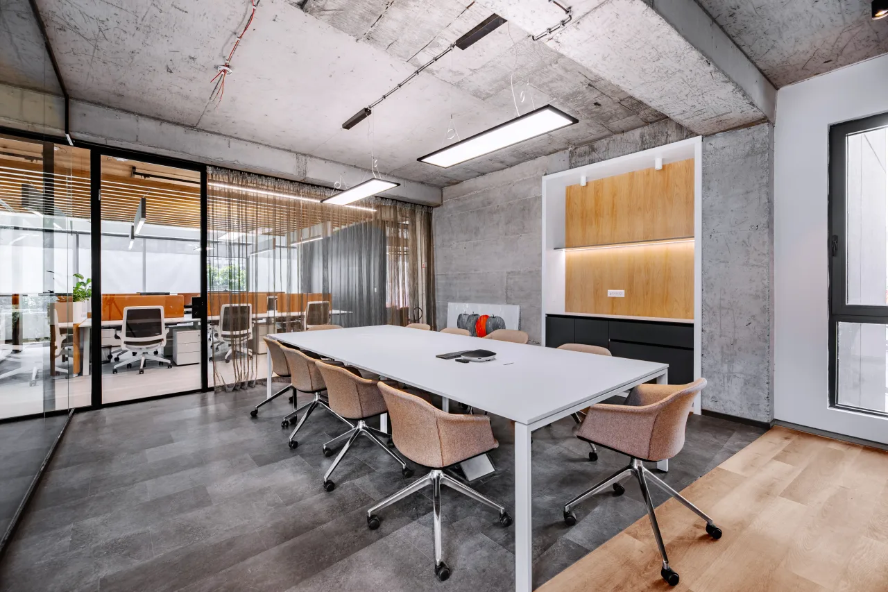 A long boardroom table seen through a glass partition
