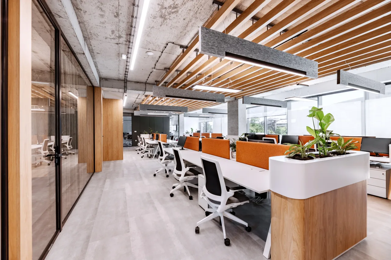 Rows of desks and monitors beside a white planter