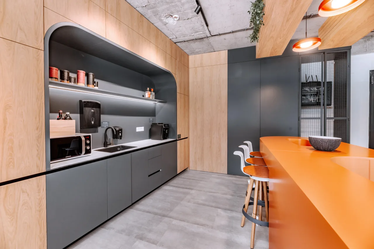 The lounge with orange sofas beside the kitchen bar and the Salience sign
