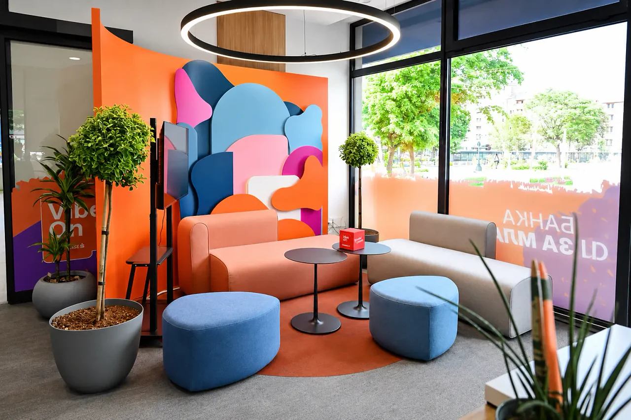 A breakout corner with orange sofas and a bold graphic wall