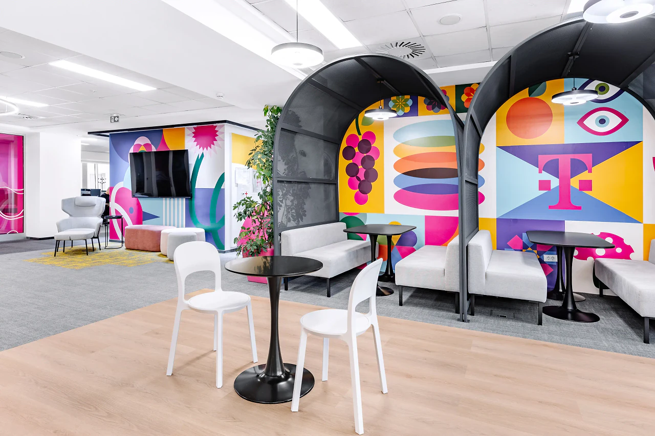 Arched booths and café tables beside a colourful graphic wall