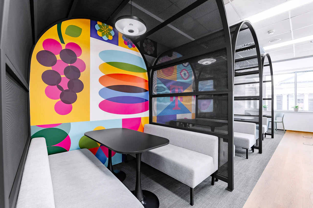 Inside an arched booth, a graphic wall of fruit and colour