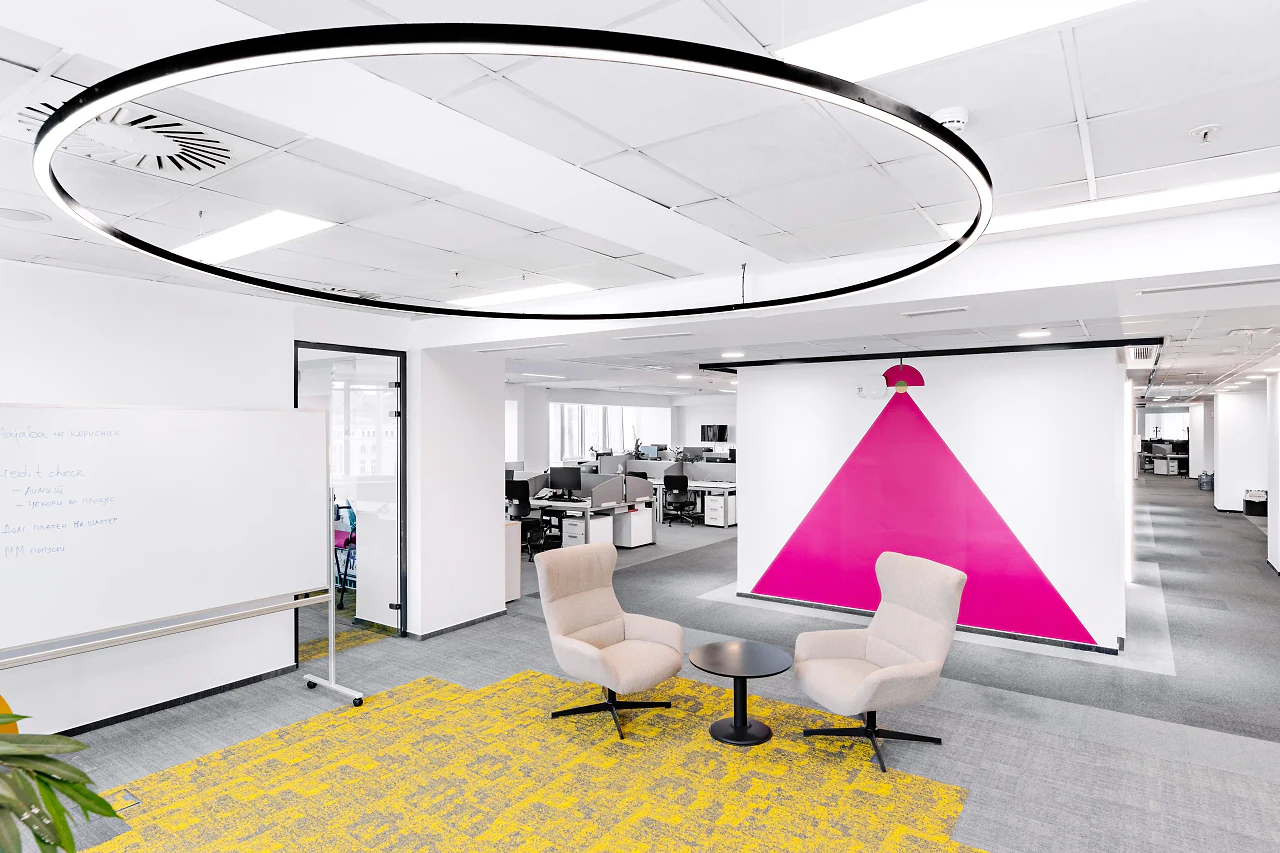 Two lounge chairs in front of a pink triangle wall