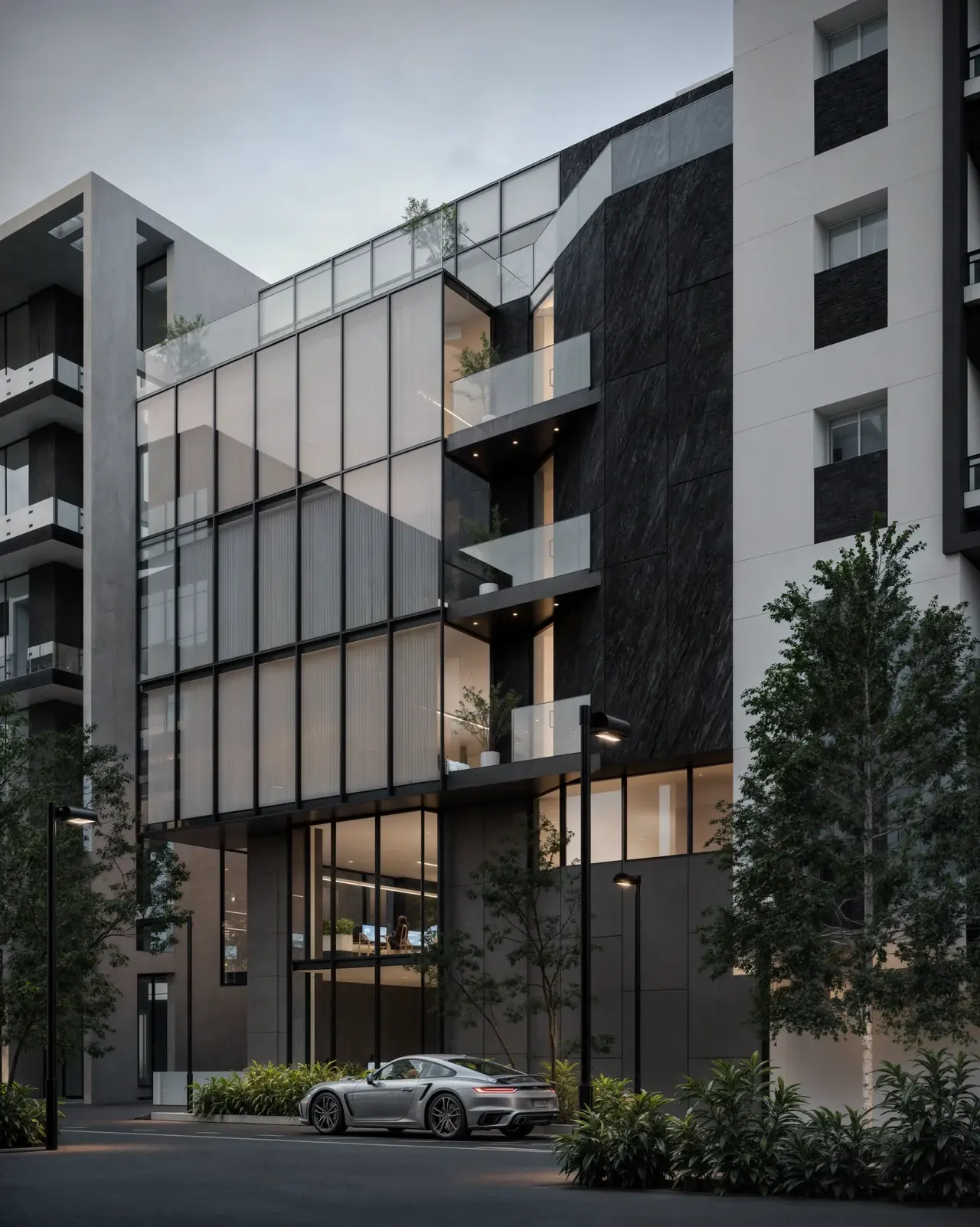 Toros Building at dusk, a glass façade over a planted street edge